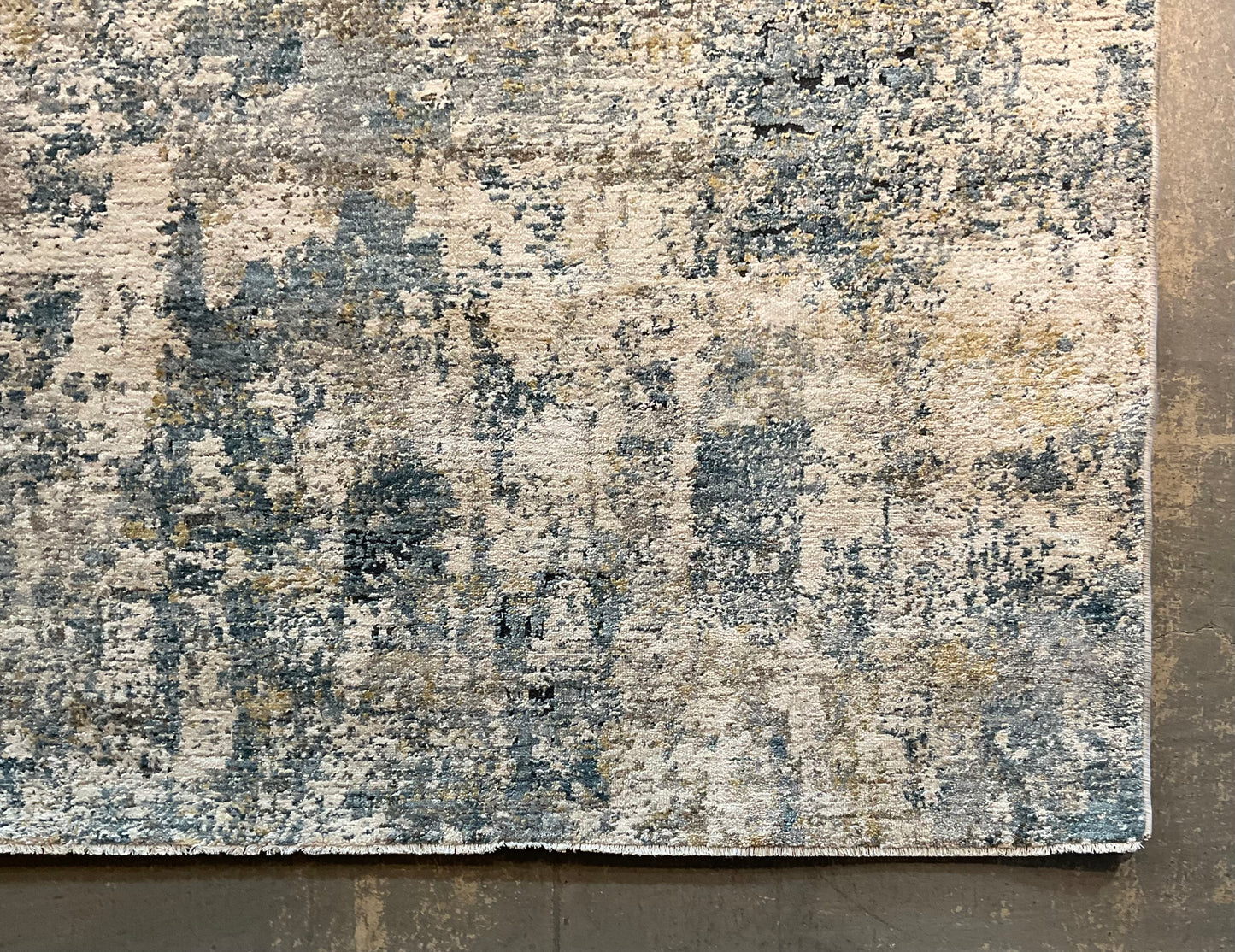 Modern rug features layered shades of blue, grey, soft gold | NU-7789