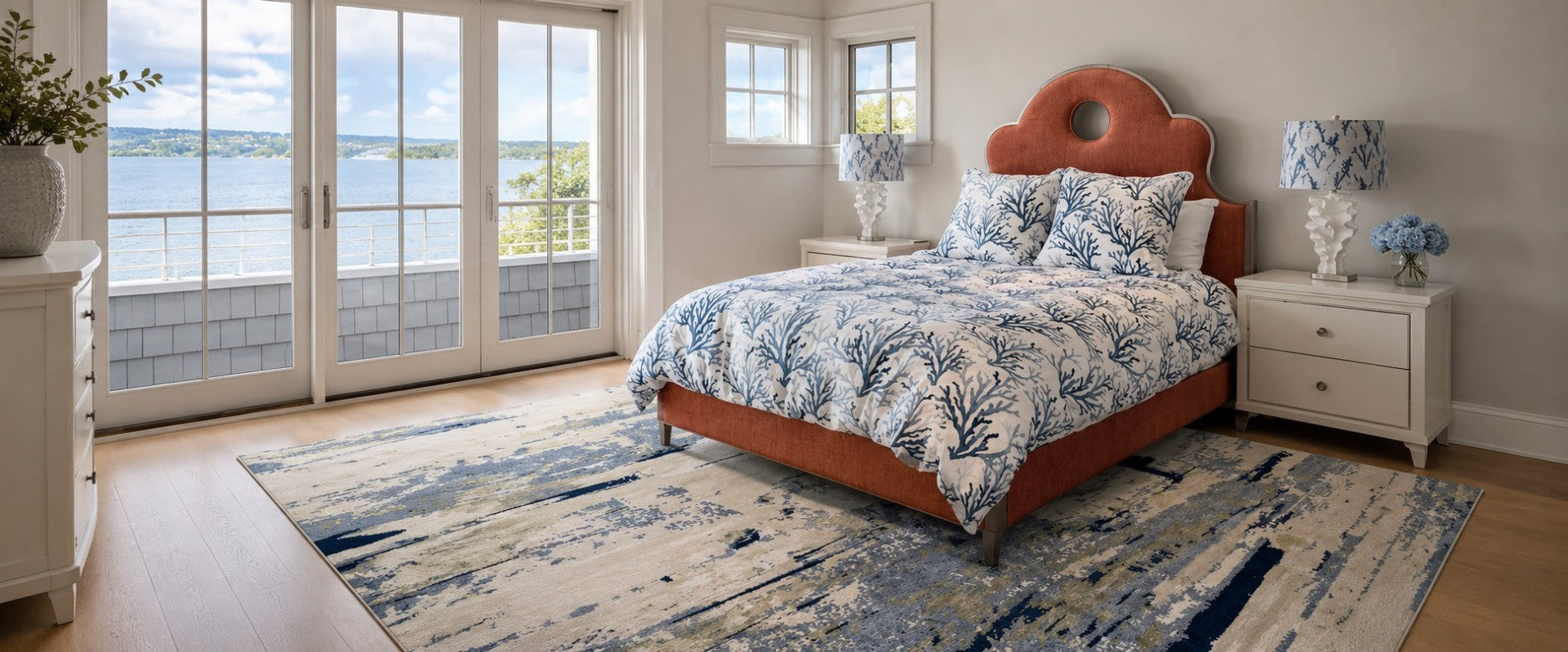 Bedroom area rug with floral bedding, wooden headboard, and large windows overlooking Bellevue water.