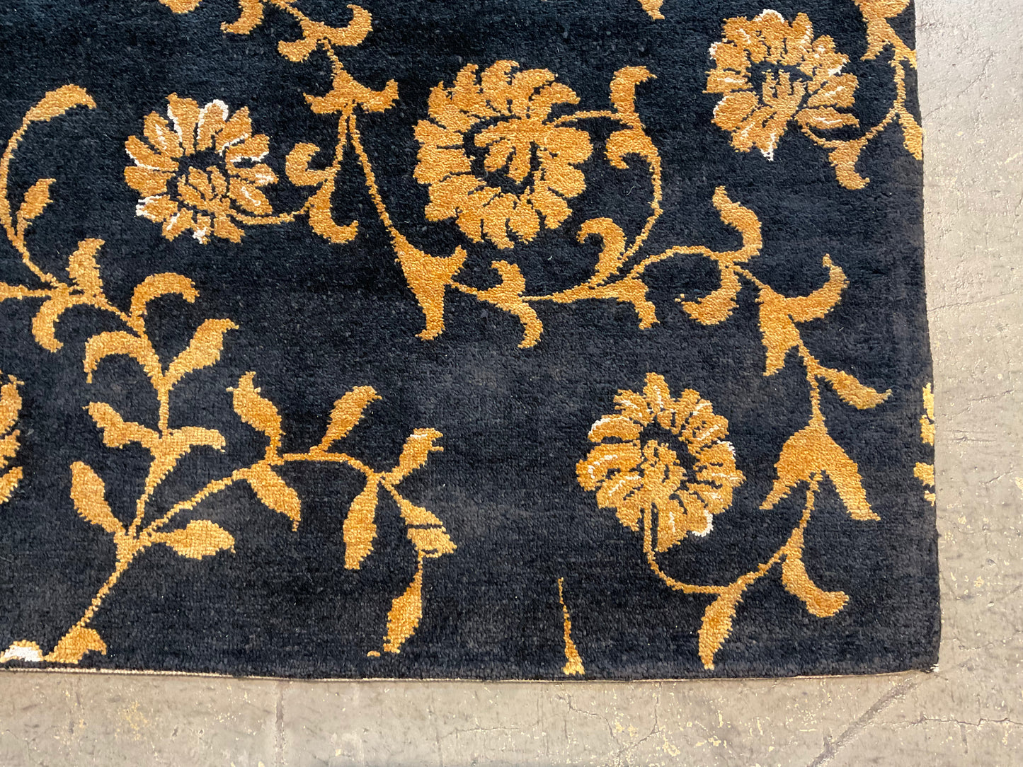 Floral design rug in a rich black and gold palette | NU-2557