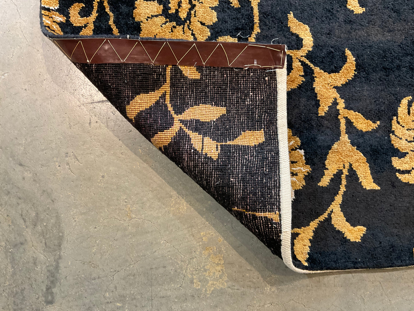 Floral design rug in a rich black and gold palette | NU-2557