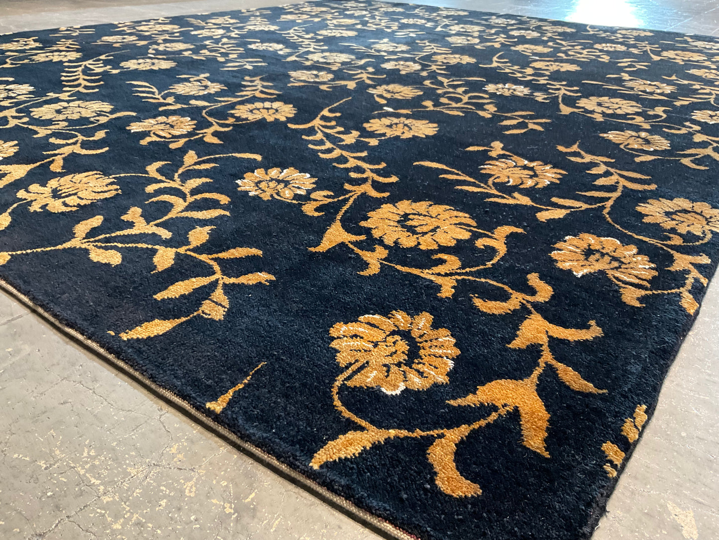 Floral design rug in a rich black and gold palette | NU-2557